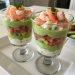 verrine avocat crevette dans un verre transparent, avec des couches d’avocat vert, de crème fraîche et de crevettes roses