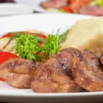 un plat de Langue de boeuf mijotée avec sauce piquante et pommes de terre sur table