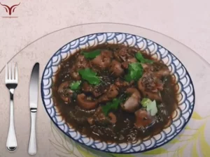 Assiette de rognons de veau à la sauce balsamique, garnie de persil et coriandre
