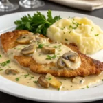 Escalope de veau nappée de sauce normande crémeuse aux champignons de Paris